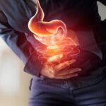 Woman holding stomach in discomfort — weight management for GERD Symptoms, acid reflux, and heartburn relief