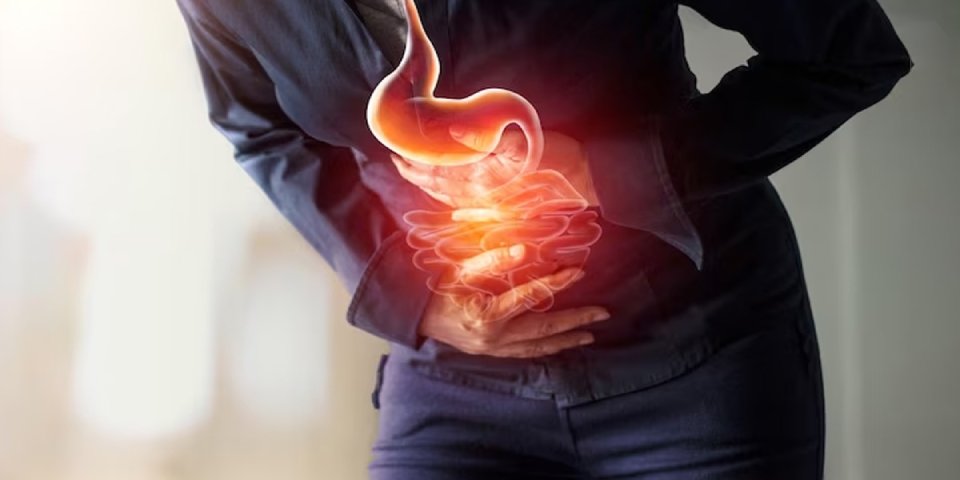 Woman holding stomach in discomfort — weight management for GERD Symptoms, acid reflux, and heartburn relief